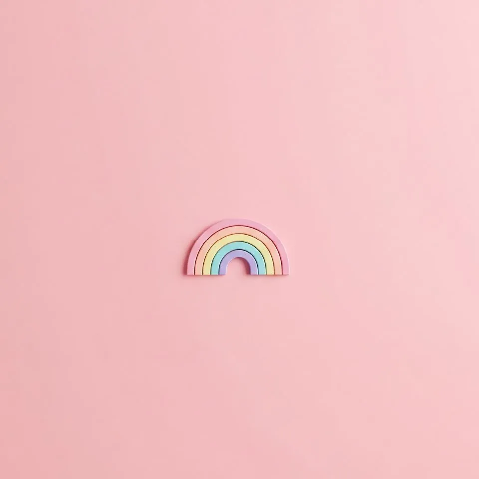 minimal pastel pink background with tiny centered rainbow icon